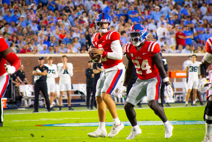 Jaxson Dart and Ulysses Bentley red jersey and blue helmet